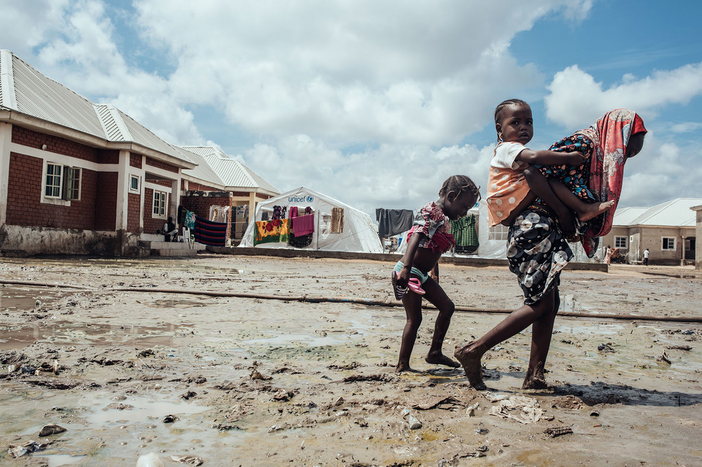 Des enfants marchent dans la boue dans un camp pour personnes déplacées à Maiduguri, dans le nord-est du Nigéria.