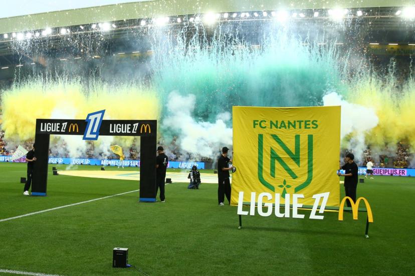 joueurs sur le terrain avec une banderole 'huit clos'