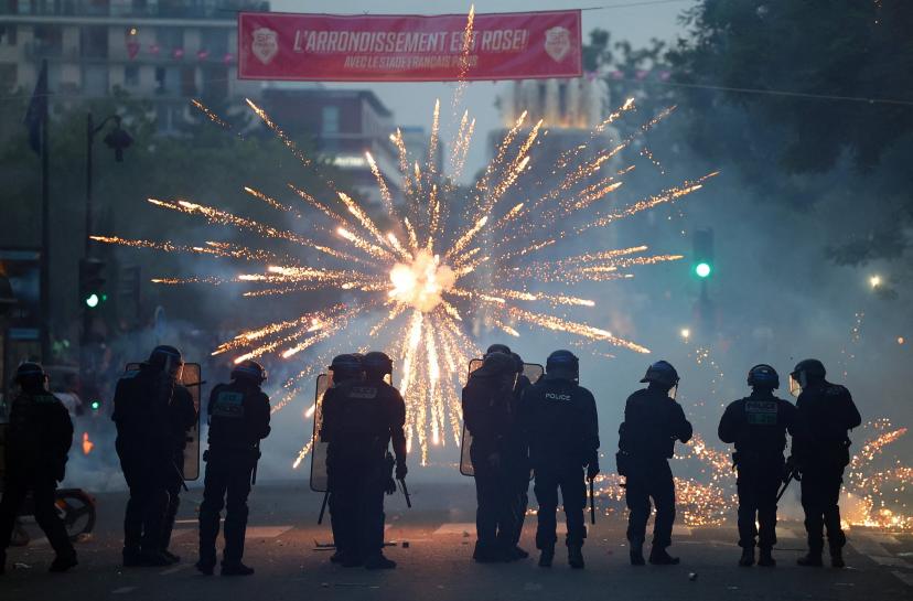 Feux d'artifice éclatant devant les forces de l'ordre lors de la célébration du PSG