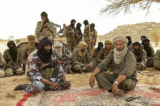 Combattants touaregs et arabes en réunion stratégique dans le désert malien