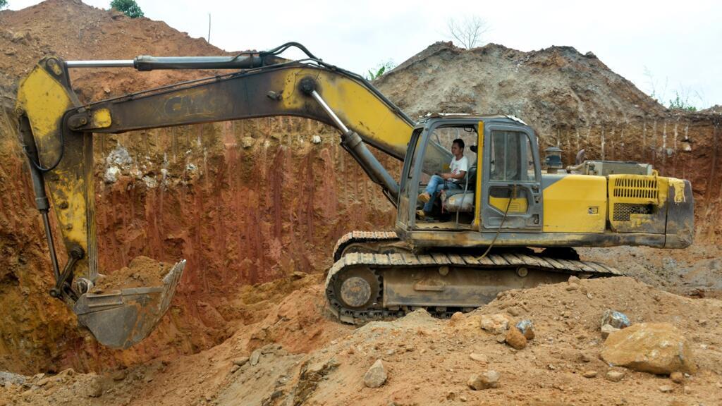 Un employé chinois d'une société minière conduit un bulldozer sur un site d'extraction d'or à Betare Oya, Cameroun.