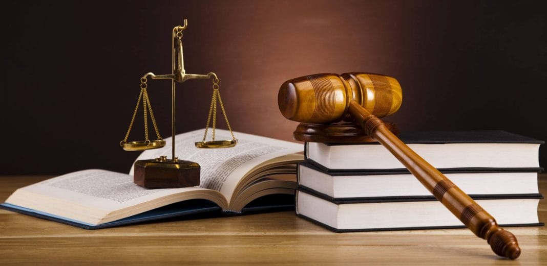 Justice et loi symbolisées par une balance et des livres